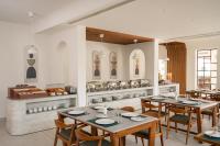 尼杜巴塞莱CASTELO Inn的餐厅里有桌椅，还有一个厨房