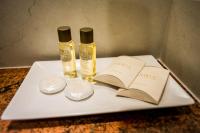 a white tray with two bottles of oils and an open book at Hotel Arnia in Iaşi
