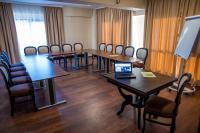 a conference room with tables and chairs and a laptop at Hotel Arnia in Iaşi