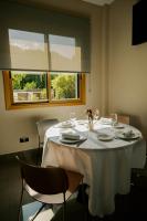 エイバルにあるHotel Eibarの白いテーブルクロスと2つの窓があるダイニングテーブル