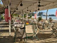 uma fila de mesas e cadeiras numa praia em Luxury 3BR Seafront Apartment, Direct Beach Access, Pool, Family-Friendly em Port Dickson