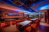 un restaurant avec des tables, des chaises et des lumières bleues dans l'établissement COMMON INN Thu Dau Mot, à Ga Phú Văn