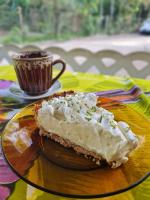 una fetta di torta su un piatto con una tazza di caffè di Vivenda Puruba a Ubatuba