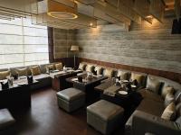 Un restaurante con sofás, mesas y sillas. en Hotel Tirupati Plaza, en Kota
