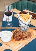 una bandeja de madera con filete, patatas fritas y una copa de vino en Oporto Fly Hotel, en Maia