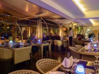 um grupo de pessoas sentadas às mesas de um restaurante em The Concord Hotel & Suites em Nairobi