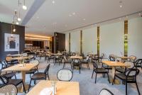 um restaurante com mesas e cadeiras em uma sala em REZEN LONGUU Hotel Guangzhou Baiyun International Airport em Huadu