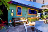 a green house with a bench and tables and chairs at Pousada DiMari in Boicucanga