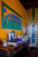 a table in a kitchen with a painting on the wall at Pousada DiMari in Boicucanga