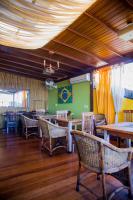 a restaurant with wooden floors and chairs and tables at Pousada DiMari in Boicucanga