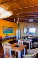 a dining room with wooden tables and chairs at Pousada DiMari in Boicucanga
