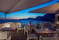 Un restaurante con mesas y sillas y vista al mar. en Casa Angelina, en Praiano