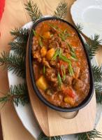 een kom stoofpot op een houten bord op tafel bij Carlsbad Wellness & Camping Resort in Pirkenhammer