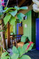 a living room with a chair and a balcony at Pousada DiMari in Boicucanga