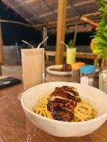 een kom pasta met vlees en saus op een tafel bij Tropictide Weligama in Weligama