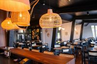 uma sala de jantar com mesas, cadeiras e lustres em Coroados Hotel & Flats em Nova Prata