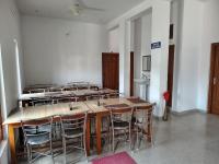 een groep tafels en stoelen in een kamer bij Nandin Guest House in Barkot