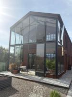 un gran edificio de cristal con un banco delante en Il Roseto dei Sensi, en Tarantasca