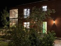 Un edificio de ladrillo con una puerta verde por la noche. en Il Roseto dei Sensi, en Tarantasca