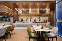 郑州Hampton by HiltonZhengzhou Xinzheng International Airport的有桌椅和柜台的餐厅