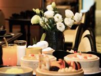 a table with plates of food and a vase of flowers at 烟台朝阳文保艺术酒店 in Yantai