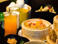 a table with a bowl of food and a glass of orange juice at 烟台朝阳文保艺术酒店 in Yantai