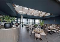 een restaurant met houten tafels en stoelen en ramen bij MNM Luxury Suit 424 in Pretoria