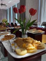 un plato de comida sobre una mesa con rosas rojas en Khách sạn San Hô Vũng Tàu (Coral Hotel), en Vung Tau