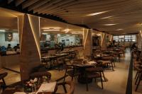 Rosepine Hotel في La Trinidad: مطعم به طاولات وكراسي وبار