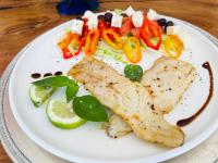 une plaque blanche avec du poisson et des légumes sur une table dans l'établissement Lions View Accommodation, à Nelspruit