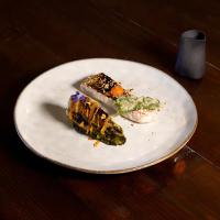 ein weißer Teller mit etwas Essen auf einem Tisch in der Unterkunft Hôtel OstOria Périgueux, BW Signature Collection in Marsac-sur-lʼIsle