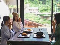 白山市千丈温泉 ペンシオーネセイモア サウナはくさん SENJO Onsen PENSIONE SEYMOUR Sauna Hakusan的一群人坐在桌旁吃饭