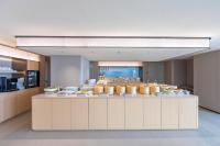 a cafeteria with a counter with food on it at JI Hotel Shanghai Pudong International Airport Huinan in Shanghai