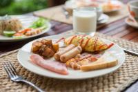 een bord voedsel op een tafel met een glas melk bij Orchard Pa La U in Ban Pa Lau