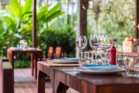 een houten tafel met wijnglazen en borden erop bij Orchard Pa La U in Ban Pa Lau