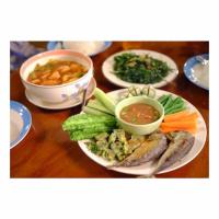 een tafel met borden met vis en groenten bij Orchard Pa La U in Ban Pa Lau