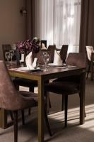 uma mesa de madeira com cadeiras e uma mesa com copos de vinho em Miznah Hotels & Resorts em Bačka Topola