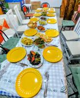 una mesa larga con platos amarillos de comida encima en Sweet Home Aria, en Zhaban