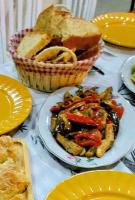 una mesa con un plato de comida y una cesta de pan en Sweet Home Aria, en Zhaban