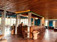 een restaurant met een bar met krukken en een persoon bij Living Ubud in Ubud