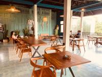 een restaurant met houten tafels en stoelen en mensen aan tafel bij Living Ubud in Ubud