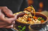 una persona comiendo arroz y carne con una cuchara en Hotel Pastos Chicos, en Susques