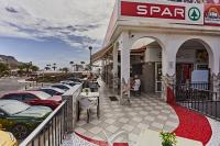 een parkeerplaats met auto's geparkeerd voor een winkel bij Casa Dorotea in Playa del Cura