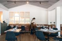 a woman standing in a dining room with wine glasses on tables at Crittenden Lakeside Villas in Dromana