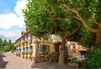 a building with a tree in front of a street at Hotel Restaurant L&#39;Ami Fritz in Ottrott
