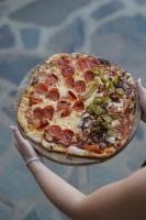 タパルパにあるHotel Puerta de Piedraの皿の上にピザを持っている人