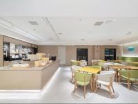 a restaurant with tables and chairs and a kitchen at JI Hotel Shanghai International Tourism Resort Chongxi Road in Nanhui