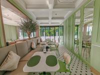 Olivia Boutique Thailand في Ban Bang Kraba: مطعم به طاولات وكراسي خضراء وبيضاء