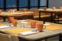 a table with orange cups and napkins on it at TMG Hotel Tebet, Marclan Collection in Jakarta