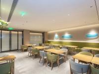 een eetkamer met houten tafels en stoelen bij JI Hotel Beijing Xizhimen in Beijing